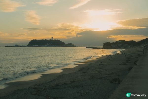 這裏是日本鎌倉的沙灘，陽光灑在金色沙灘上，海浪輕輕拍打岸邊，...