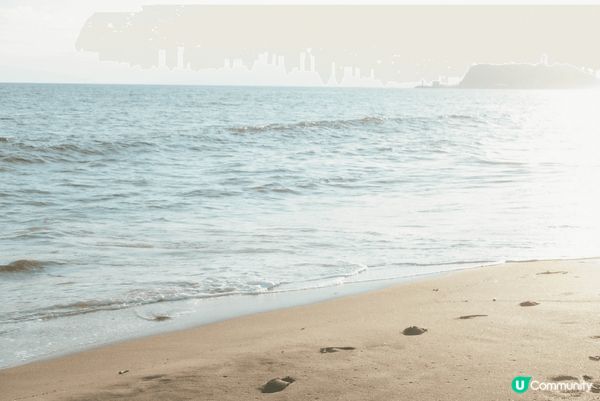 這裏是日本鎌倉的沙灘，陽光灑在金色沙灘上，海浪輕輕拍打岸邊，...