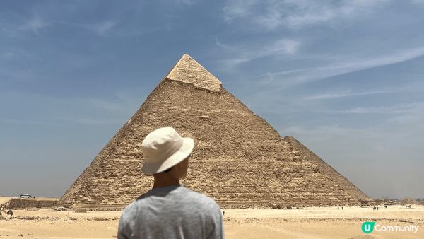 這張背影照攝於埃及吉薩高原，我站在壯觀的胡夫金字塔前，陽光將...