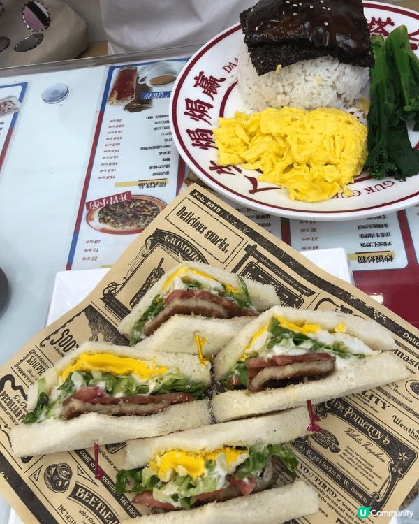 这是一张美食图片，展示了一份美味的三明治和一份精致的甜点。三...