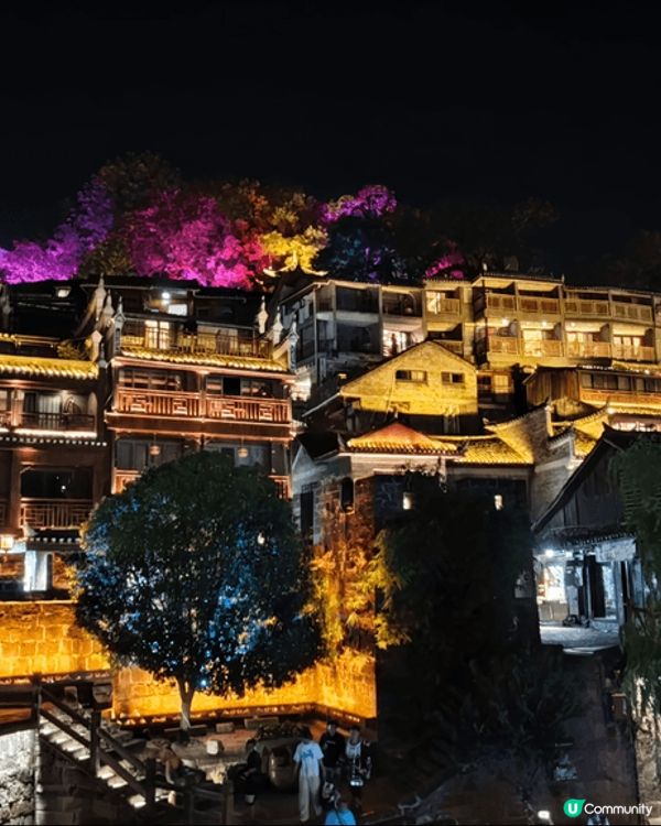 夜遊湖南鳳凰古城，河邊有大量穿著苗族傳統服飾的遊客以兩岸的舊...