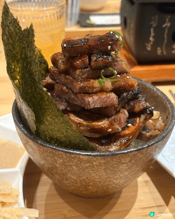 成座山咁高嘅厚切燒牛肉堆滿成個飯碗，上面有焦香肉汁同芝麻點綴...