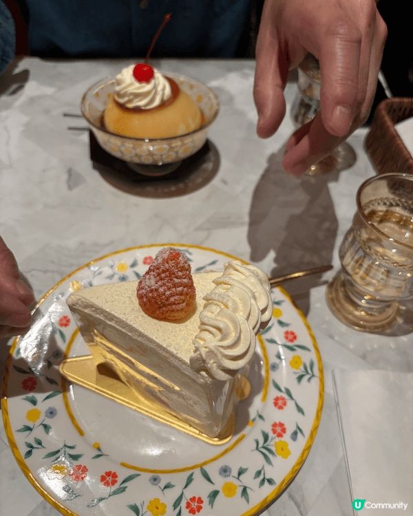 草莓鮮奶油蛋糕：一片裝飾著鮮奶油花邊和一顆草莓的白色蛋糕，放...