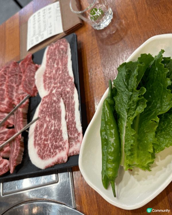 一份韓式烤肉套餐，包含生牛肉片、蘿蔓萵苣和青辣椒。牛肉是一種...