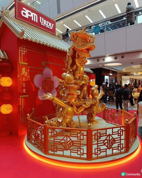 這個新春造景以金色舞龍與唐老鴨角色為焦點，紅金燈籠與吉祥字句...