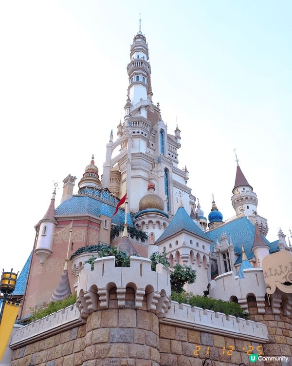 呢張照片係聖誕節期間嘅迪士尼夜景，燈飾閃爍，充滿節日氣氛。夜...