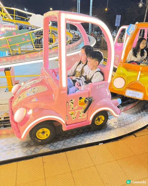 這是新會夜市遊樂場的兒童電動車遊樂設施，三輛可愛卡通車（粉紅...