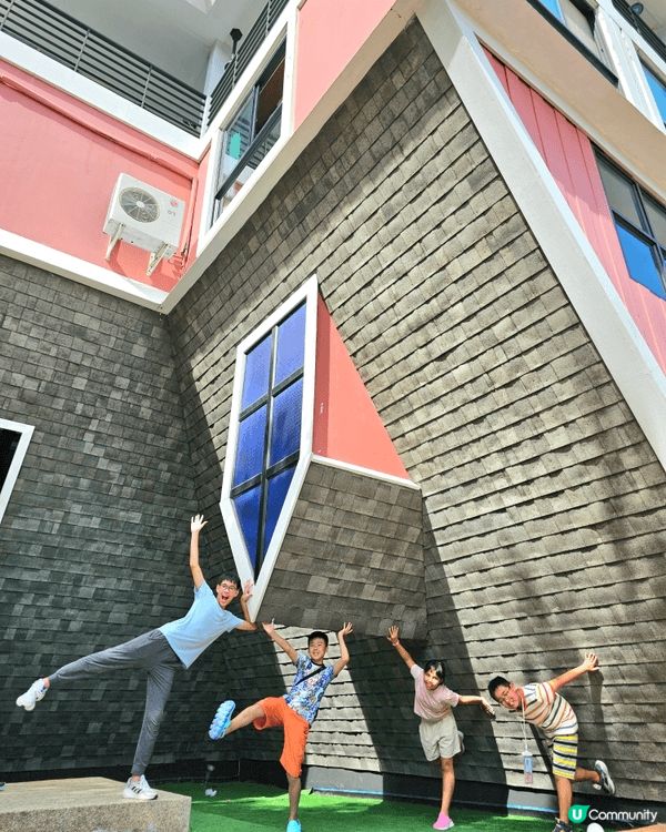 這是一張在泰國「芭達雅顛倒屋」拍攝的趣味合照。建築物完全倒轉...