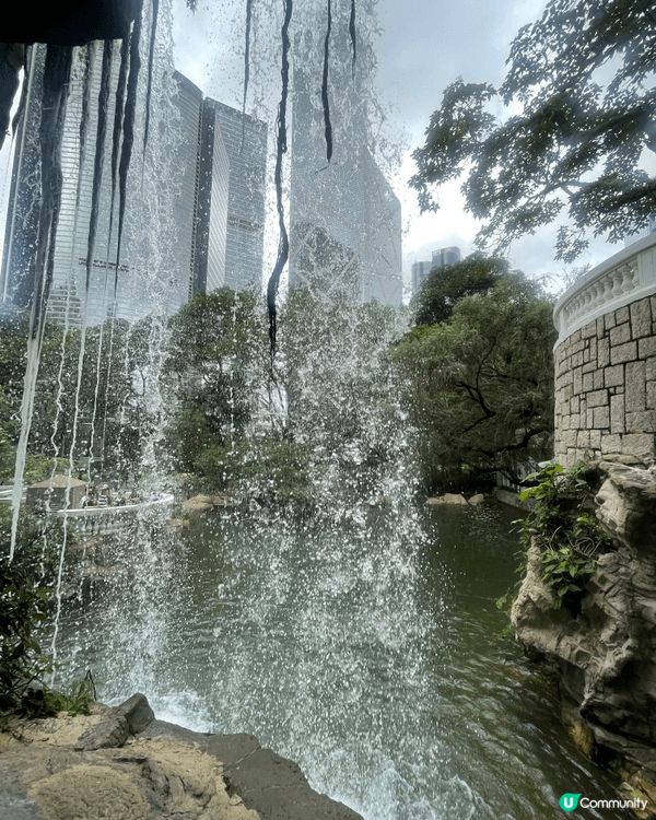 這張照片拍下了香港公園壯觀的瀑布，在宏偉的摩天大樓包圍下，這...