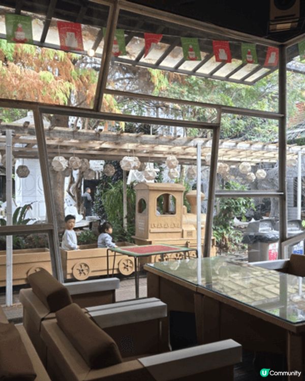 圖片是台中紙箱王創意園區的特色造景，陽光與綠意配合紙藝裝置，...