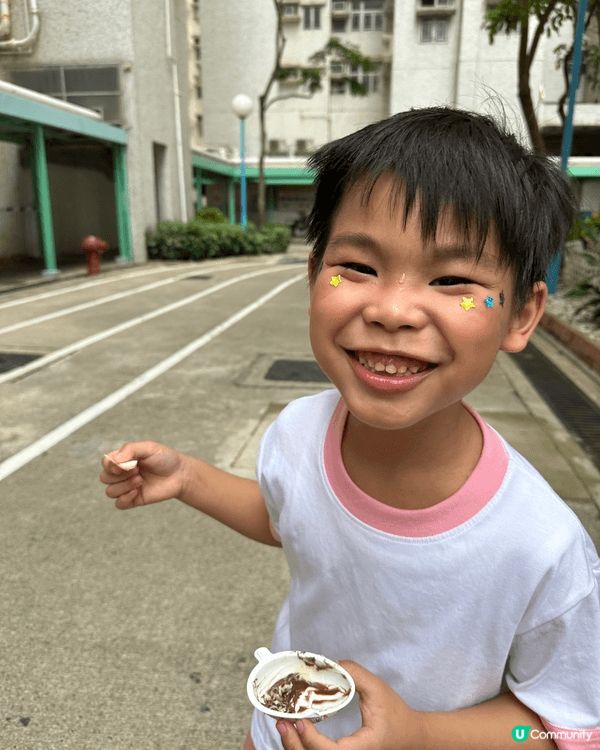 這張照片拍攝於戶外兒童水上樂園，兩位小朋友在噴水池之中開心玩...