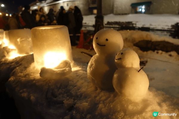 小樽運河的夜晚雪景像一幅溫暖又寒冷的油畫：黃燈柔和地灑在白雪...